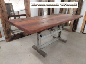 Industriele eettafel met oud verstelbaar onderstel en een blad van oude hardhouten wagonplanken