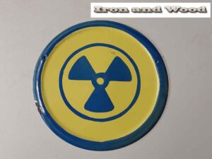Oud emaille rond geel donkerblauw waarschuwingsbord radioactief